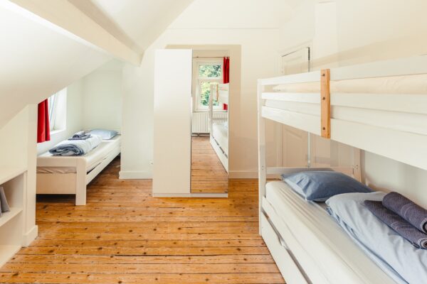 Kinderkamer met stapelbed, enkel bed en retro-spelconsoles